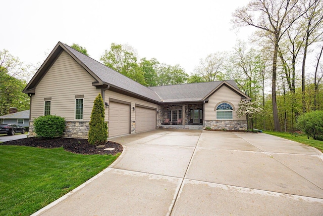 ranch-style home with an attached garage, driveway, stone siding, and a front lawn