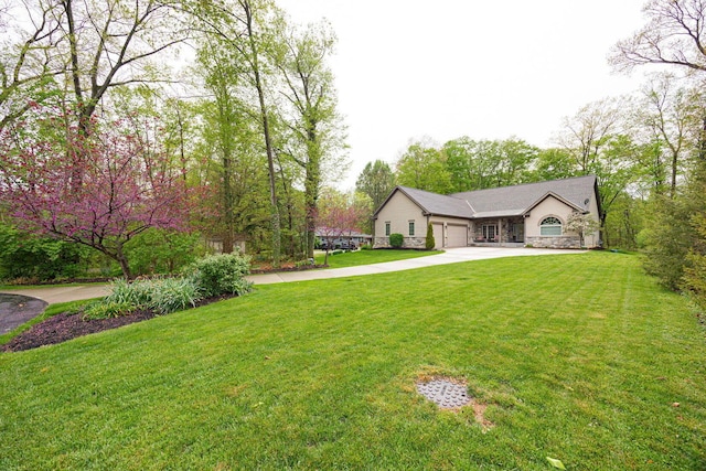 view of grassy yard featuring driveway and a garage