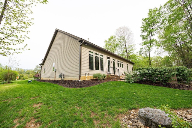 view of property exterior featuring a lawn and entry steps