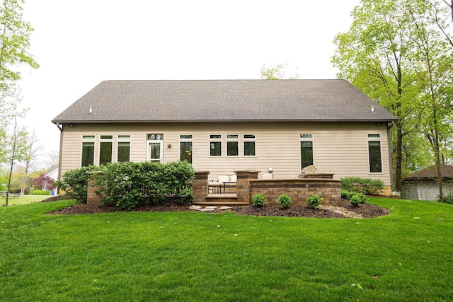 rear view of property with a lawn and a shingled roof