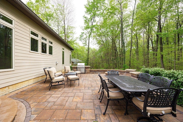 view of patio / terrace featuring outdoor dining space, area for grilling, and a grill