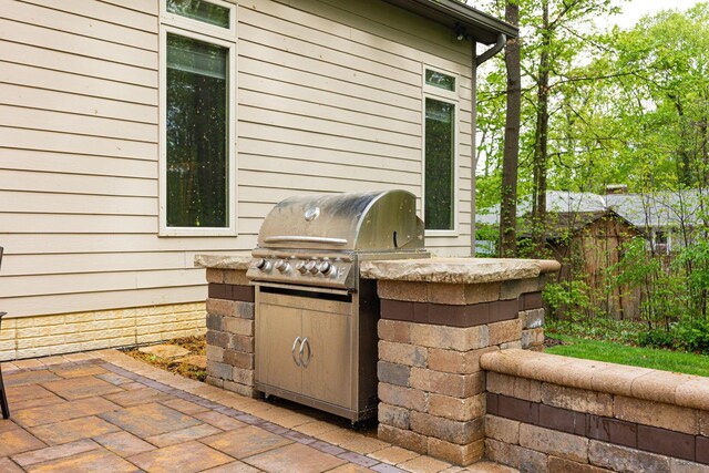 view of patio / terrace with exterior kitchen, fence, and grilling area