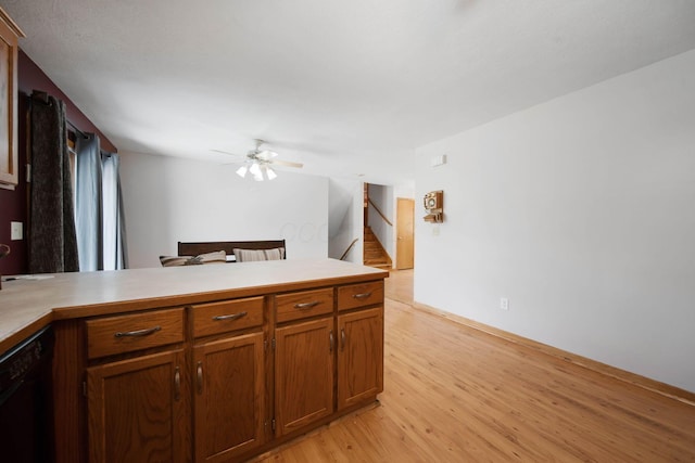 134 Hasbrouck Cir, Howard, OH 43028 - kitchen with light wood-style flooring, ceiling fan, light countertops, brown cabinetry, and black dishwasher