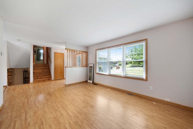134 Hasbrouck Cir, Howard, OH 43028 - unfurnished living room featuring light wood finished floors, baseboards, and stairway
