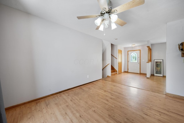 134 Hasbrouck Cir, Howard, OH 43028 - unfurnished living room featuring stairs, wood finished floors, a ceiling fan, and baseboards