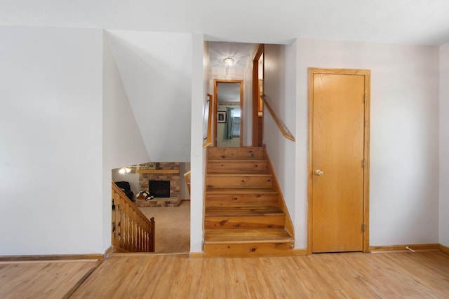 134 Hasbrouck Cir, Howard, OH 43028 - stairway with wood finished floors, baseboards, and a fireplace with raised hearth