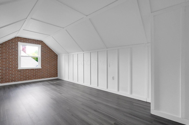 1666 Northridge Rd, Columbus, OH 43224 - bonus room with dark wood-style flooring, brick wall, lofted ceiling, and baseboards