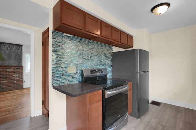1666 Northridge Rd, Columbus, OH 43224 - kitchen with electric range, dark countertops, light wood finished floors, decorative backsplash, and baseboards