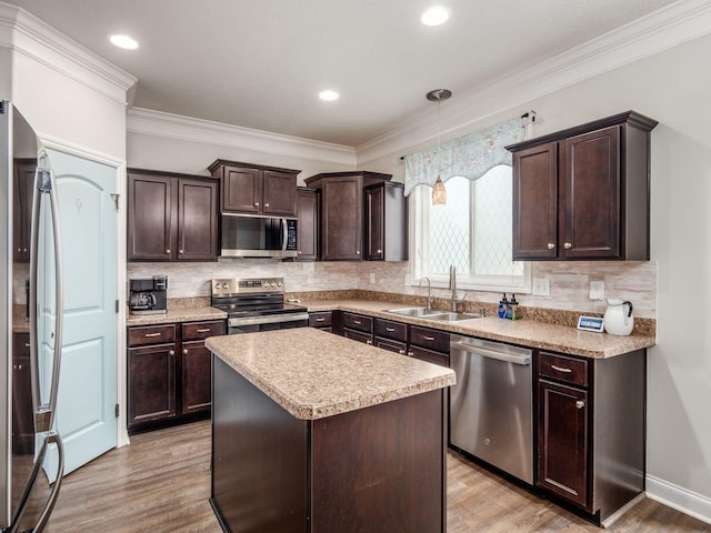 9035 Strawser St, Orient, OH 43146 - kitchen featuring appliances with stainless steel finishes, a sink, dark brown cabinetry, light wood finished floors, and crown molding