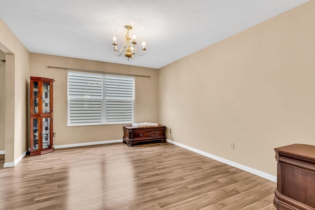 5556 Falco Dr, Westerville, OH 43081 - empty room featuring a chandelier, wood finished floors, and baseboards