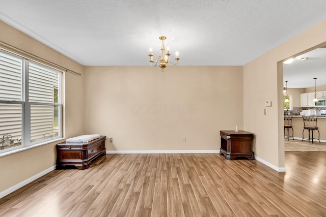 5556 Falco Dr, Westerville, OH 43081 - unfurnished room featuring light wood-style floors, a chandelier, and baseboards