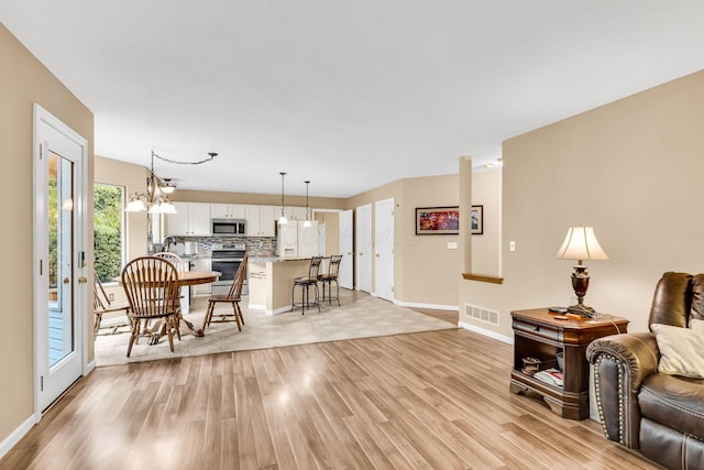 5556 Falco Dr, Westerville, OH 43081 - living area with light wood-style flooring, baseboards, and a chandelier