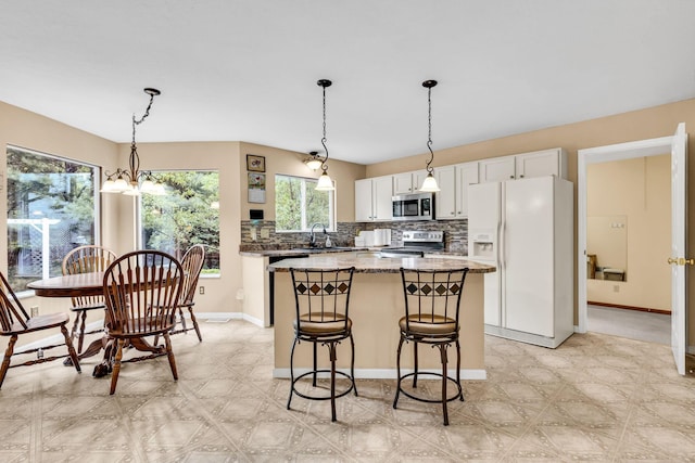 5556 Falco Dr, Westerville, OH 43081 - kitchen with stainless steel appliances, a kitchen island, decorative backsplash, a sink, and light flooring