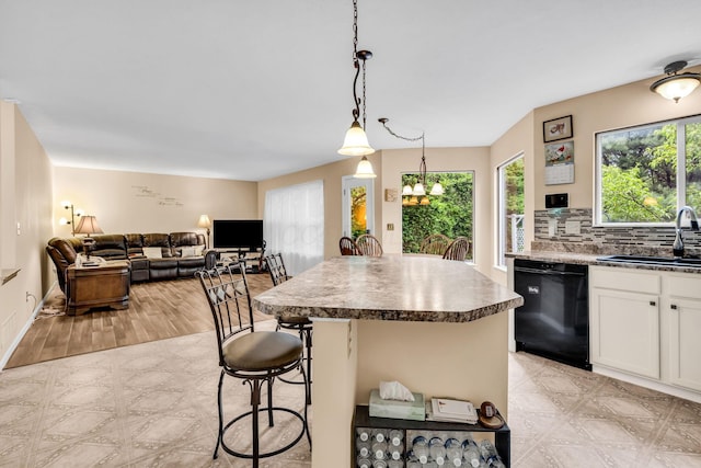 5556 Falco Dr, Westerville, OH 43081 - kitchen featuring dishwasher, a sink, white cabinetry, a center island, and a kitchen bar