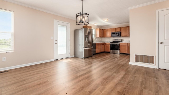 776 Brevard Cir, Pickerington, OH 43147 - kitchen with appliances with stainless steel finishes, a chandelier, light countertops, ornamental molding, and light wood finished floors