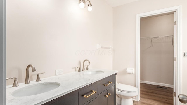 776 Brevard Cir, Pickerington, OH 43147 - bathroom with toilet, a spacious closet, wood finished floors, double vanity, and baseboards