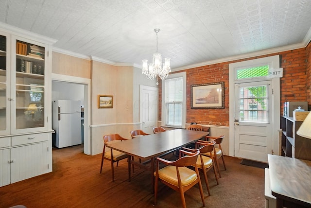 699 S Front St, Columbus, OH 43206 - dining space featuring a chandelier, crown molding, wainscoting, and brick wall