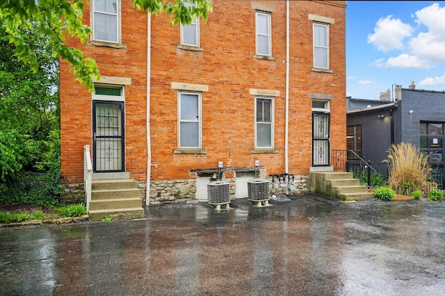 699 S Front St, Columbus, OH 43206 - back of house with brick siding, entry steps, cooling unit, and a water view