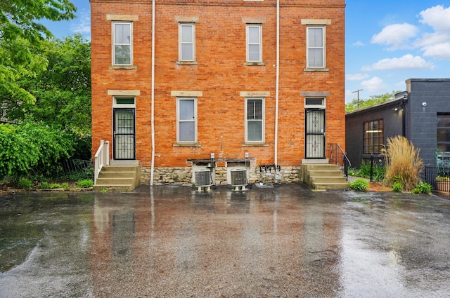 699 S Front St, Columbus, OH 43206 - rear view of house with entry steps, brick siding, and central AC
