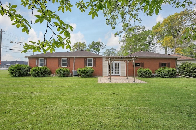 back of house featuring brick siding, a lawn, french doors, and a patio