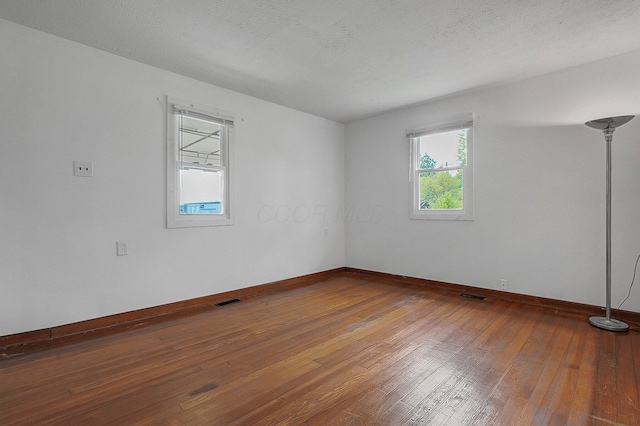 empty room with hardwood / wood-style flooring and baseboards