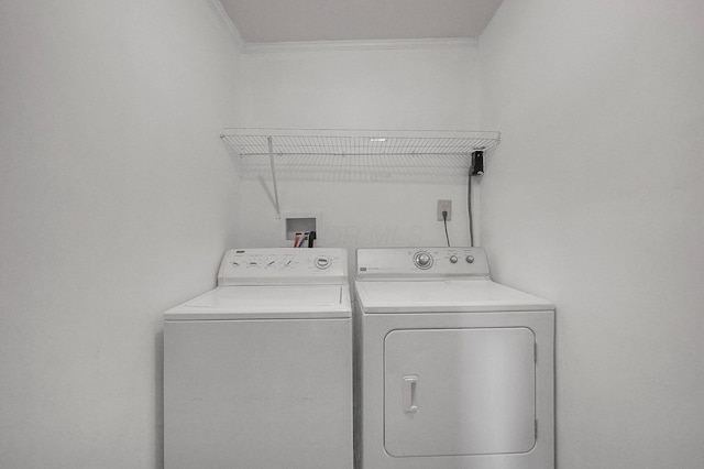 clothes washing area featuring washer and dryer and ornamental molding