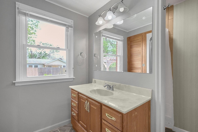bathroom featuring crown molding, baseboards, and vanity
