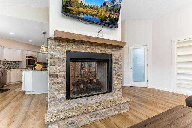1885 Greenbriar Way, Nashport, OH 43830 - detailed view of a multi sided fireplace, wood finished floors, appliances with stainless steel finishes, tasteful backsplash, and recessed lighting