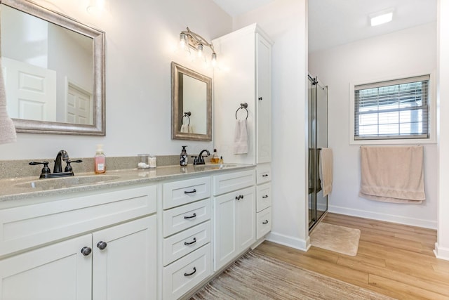 1885 Greenbriar Way, Nashport, OH 43830 - bathroom with wood finished floors, double vanity, an enclosed shower, and baseboards