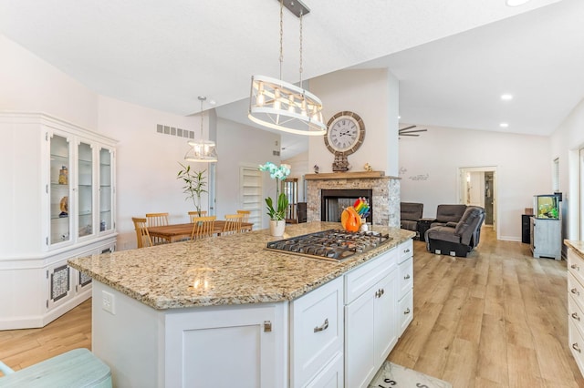 1885 Greenbriar Way, Nashport, OH 43830 - kitchen with stainless steel gas cooktop, light wood-style floors, white cabinetry, a center island, and light stone countertops