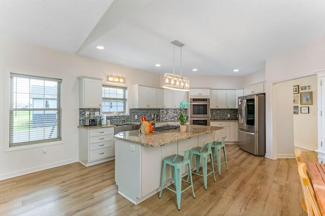 1885 Greenbriar Way, Nashport, OH 43830 - kitchen featuring stainless steel appliances, tasteful backsplash, a kitchen island, a sink, and a breakfast bar