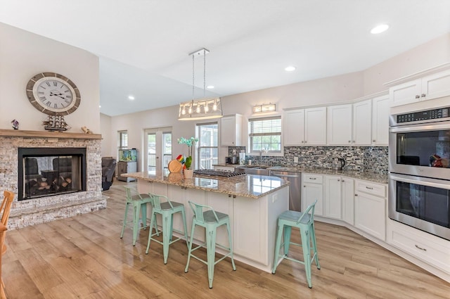 1885 Greenbriar Way, Nashport, OH 43830 - kitchen featuring appliances with stainless steel finishes, a kitchen island, a sink, light wood-type flooring, and white cabinets