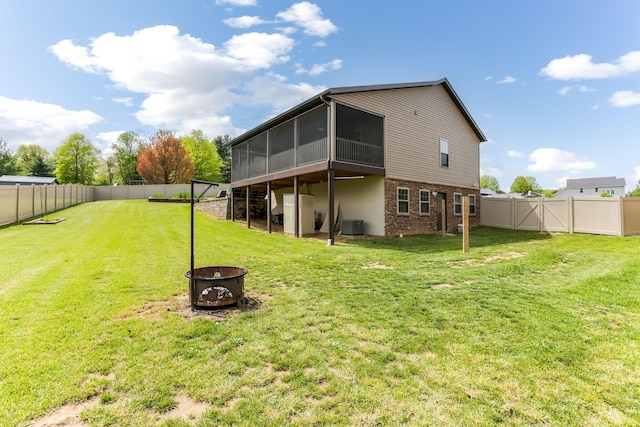 1885 Greenbriar Way, Nashport, OH 43830 - back of property featuring an outdoor fire pit, a sunroom, brick siding, and central AC