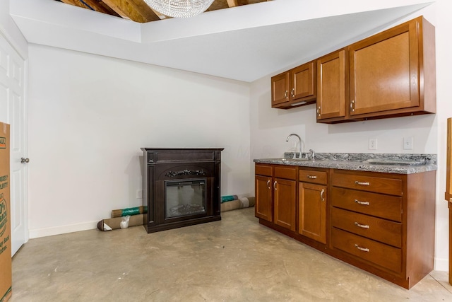 1885 Greenbriar Way, Nashport, OH 43830 - kitchen with a sink, finished concrete floors, brown cabinetry, and a glass covered fireplace