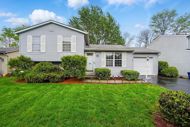 tri-level home with driveway, an attached garage, a front yard, and a shingled roof