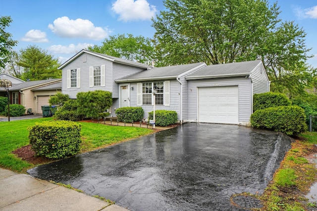 split level home with an attached garage, asphalt driveway, a front lawn, and a shingled roof