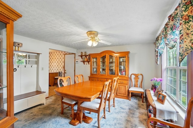 carpeted dining room featuring a ceiling fan and a textured ceiling