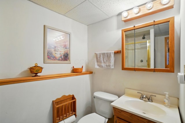 full bathroom with a paneled ceiling, a stall shower, vanity, and toilet