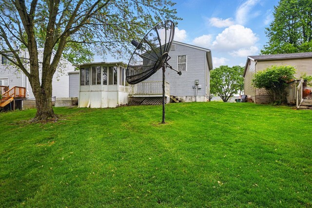 rear view of property with a sunroom and a lawn