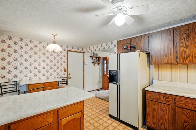 kitchen featuring white fridge with ice dispenser, wallpapered walls, a textured ceiling, light countertops, and ceiling fan