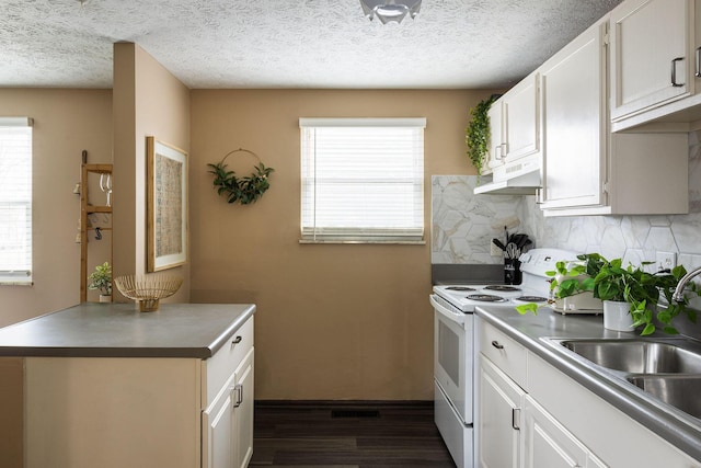 kitchen with electric stove, dark wood-type flooring, under cabinet range hood, plenty of natural light, and a textured ceiling