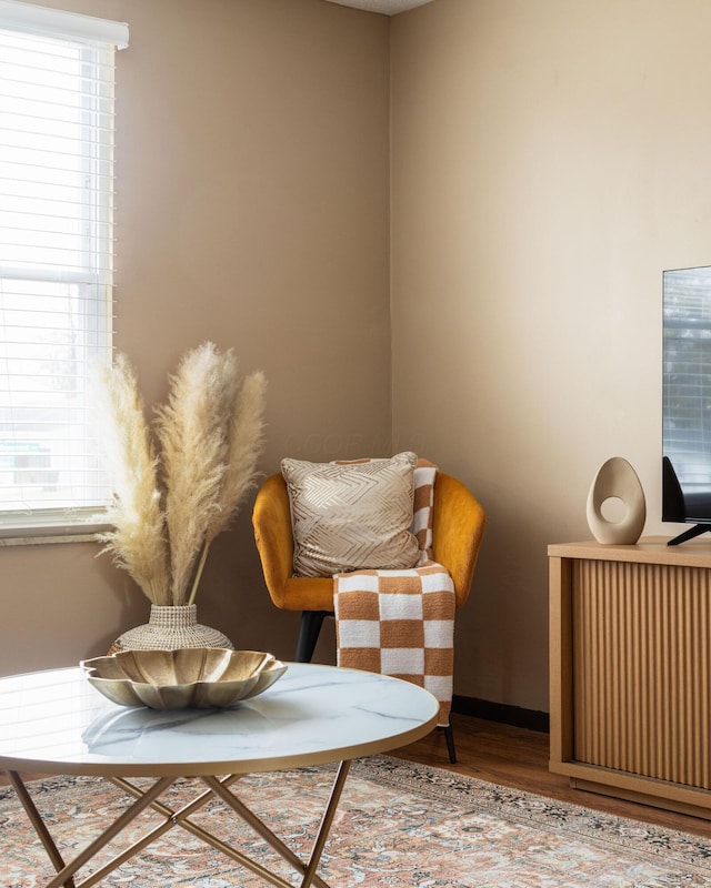 living area featuring wood finished floors, plenty of natural light, baseboards, and radiator