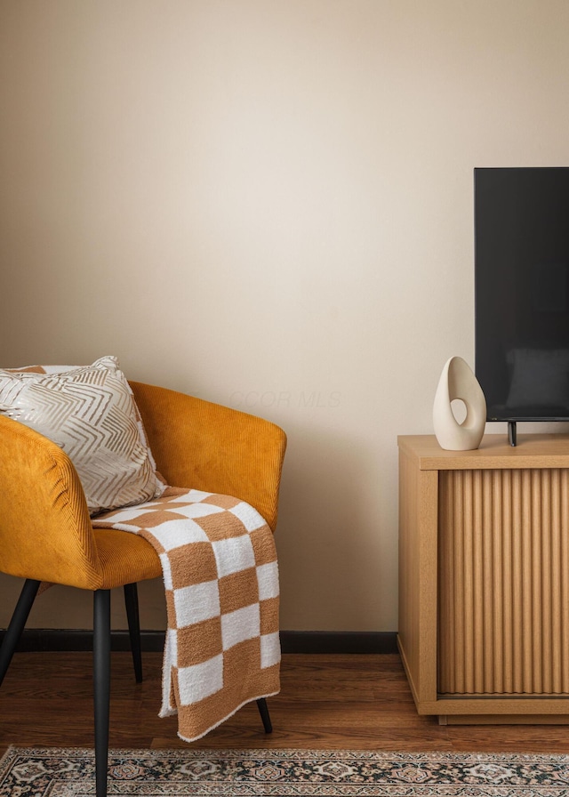 living area featuring wood finished floors, radiator heating unit, and baseboards