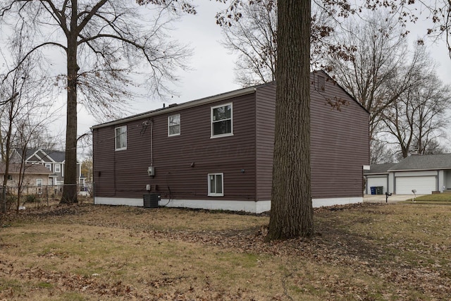 view of side of property with a detached garage and cooling unit