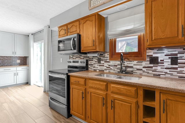 113 Bridgeport Way, Delaware, OH 43015 - kitchen featuring appliances with stainless steel finishes, decorative backsplash, plenty of natural light, a textured ceiling, and light stone counters