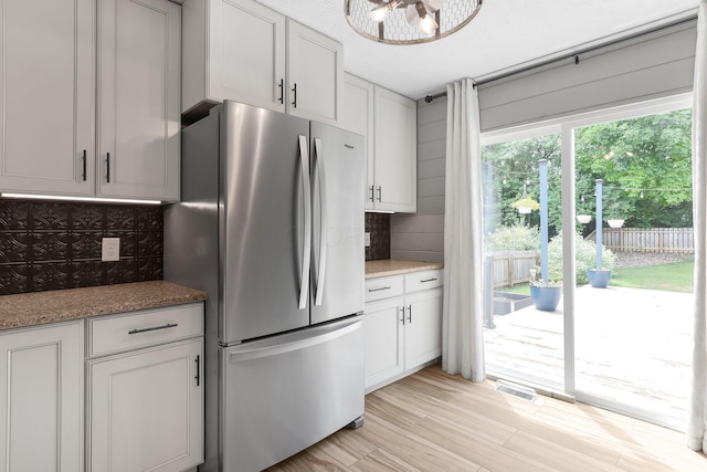 113 Bridgeport Way, Delaware, OH 43015 - kitchen with freestanding refrigerator, tasteful backsplash, light wood finished floors, and stone countertops