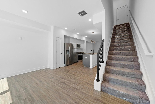 1106 Oak St Unit 12, Columbus, OH 43205 - stairs featuring wood finished floors, recessed lighting, and baseboards