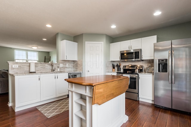 5958 Central College Rd, New Albany, OH 43054 - kitchen with stainless steel appliances, dark wood finished floors, a peninsula, white cabinetry, and recessed lighting