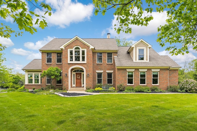 5098 Cascade Dr, Powell, OH 43065 - colonial home with a front yard, brick siding, a chimney, and roof with shingles