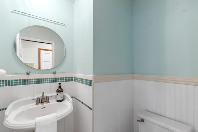 5098 Cascade Dr, Powell, OH 43065 - half bath featuring a sink, toilet, and a wainscoted wall